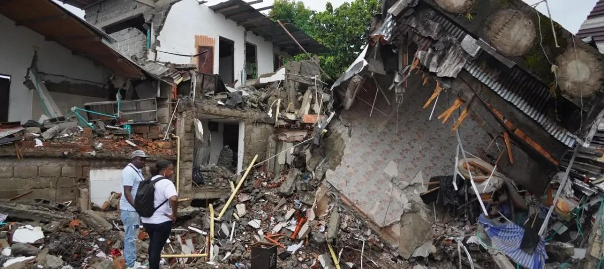 Dos personas observan una vivienda derrumbada tras el sismo